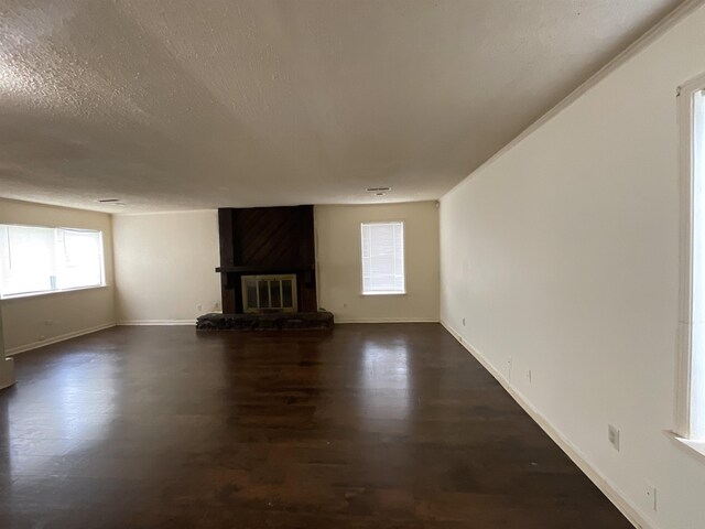 4805 Northfield Cir, Memphis, TN 38128 - unfurnished living room featuring a textured ceiling, baseboards, dark wood finished floors, and a large fireplace