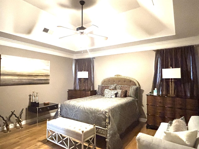 10202 Wynmanor Dr, Collierville, TN 38017 - bedroom featuring a tray ceiling, wood finished floors, baseboards, a ceiling fan, and ornamental molding