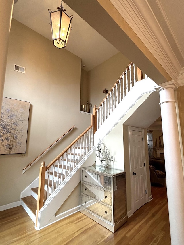 10202 Wynmanor Dr, Collierville, TN 38017 - staircase featuring wood finished floors, ornate columns, baseboards, and a towering ceiling
