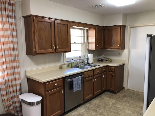 kitchen featuring light countertops, appliances with stainless steel finishes, a sink, and visible vents