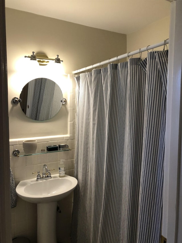 bathroom with a shower with curtain, tile walls, and backsplash