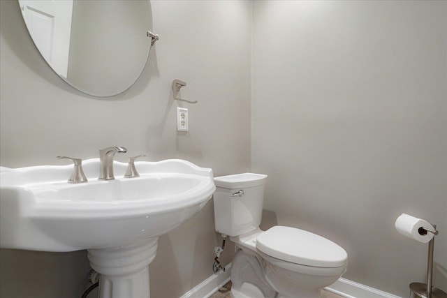 bathroom featuring baseboards and toilet