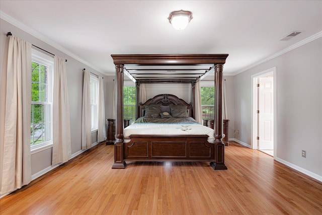 bedroom with baseboards, visible vents, ornamental molding, and light wood-style floors