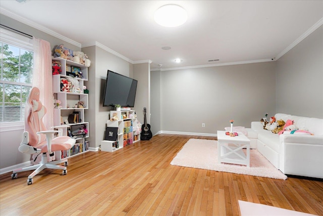 living area featuring baseboards, ornamental molding, wood finished floors, and visible vents