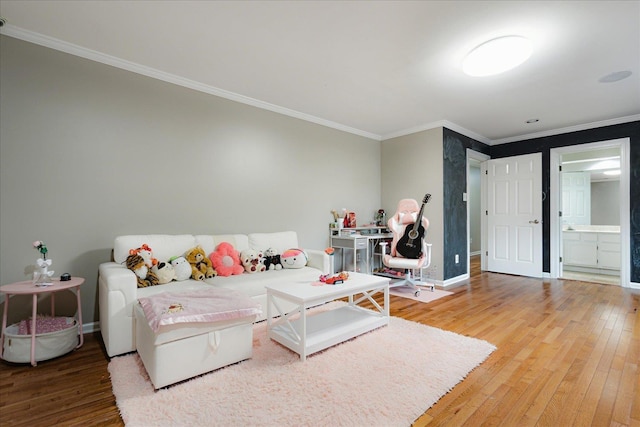 bedroom featuring crown molding, connected bathroom, baseboards, and hardwood / wood-style floors