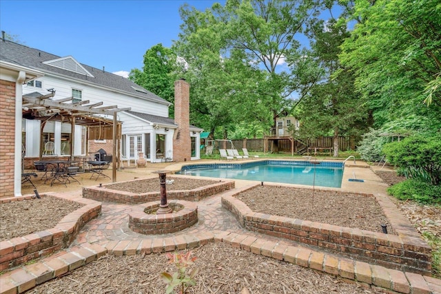 view of pool featuring a pergola, a fenced backyard, a fenced in pool, a patio area, and french doors