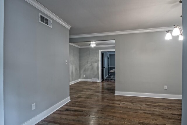 unfurnished room with visible vents, ornamental molding, dark wood finished floors, and baseboards