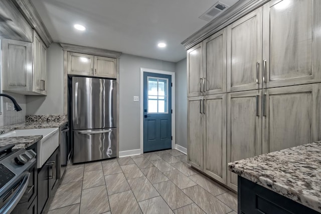kitchen featuring visible vents, light stone countertops, baseboards, recessed lighting, and appliances with stainless steel finishes