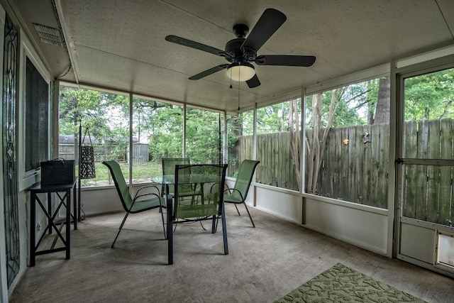 sunroom featuring plenty of natural light, outdoor dining area, and ceiling fan