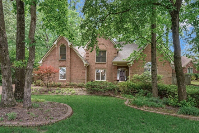 819 N Tree Dr, Collierville, TN 38017 - tudor-style house featuring brick siding, a front yard, and roof with shingles