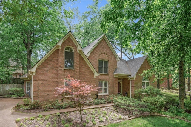 819 N Tree Dr, Collierville, TN 38017 - tudor home featuring brick siding, roof with shingles, and fence