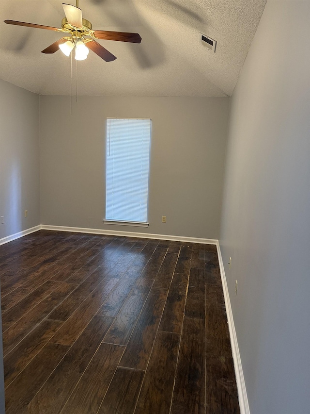 unfurnished room with dark wood-style flooring, ceiling fan, visible vents, and baseboards