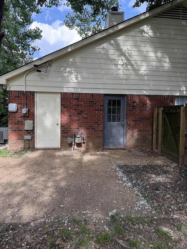 exterior space with brick siding and a chimney