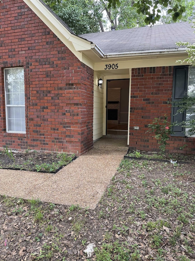 property entrance with brick siding and a shingled roof