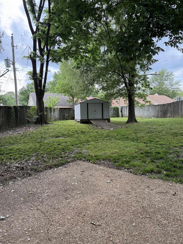 view of yard with a storage unit, a fenced backyard, and an outdoor structure