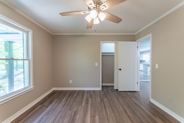 unfurnished bedroom with baseboards, multiple windows, and dark wood-style flooring