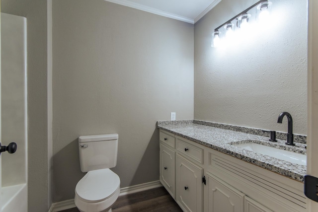 bathroom featuring vanity, crown molding, wood finished floors, toilet, and baseboards