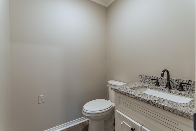 bathroom featuring crown molding, vanity, toilet, baseboards, and wood finished floors