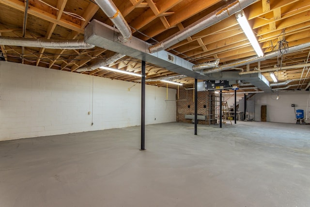unfinished basement featuring visible vents and concrete block wall