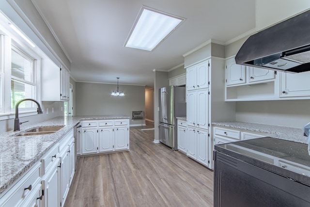kitchen with crown molding, an inviting chandelier, a sink, ventilation hood, and freestanding refrigerator