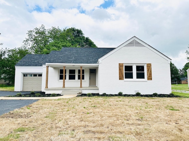 424 Tipton St S, Munford, TN 38058 - view of front of home featuring a garage, covered porch, a front lawn, and brick siding