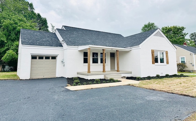 424 Tipton St S, Munford, TN 38058 - view of front facade with roof with shingles, an attached garage, a porch, and brick siding