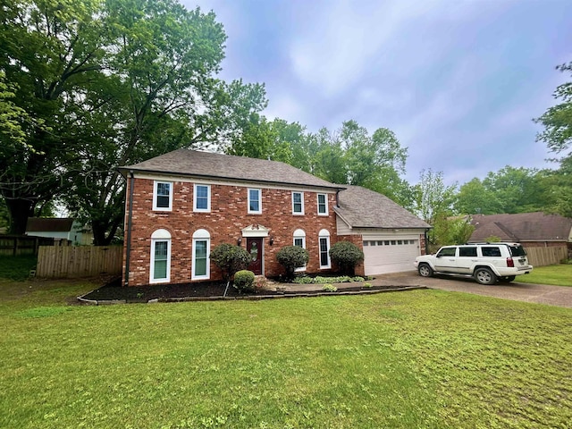 colonial house featuring fence, concrete driveway, a front lawn, and a garage