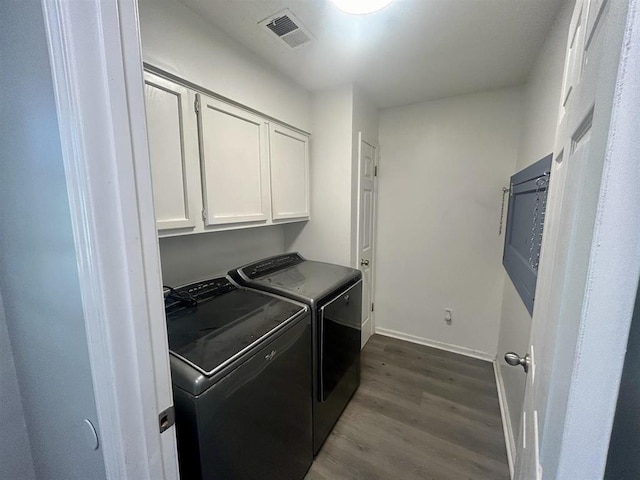 washroom featuring cabinet space, dark wood finished floors, baseboards, visible vents, and washing machine and dryer