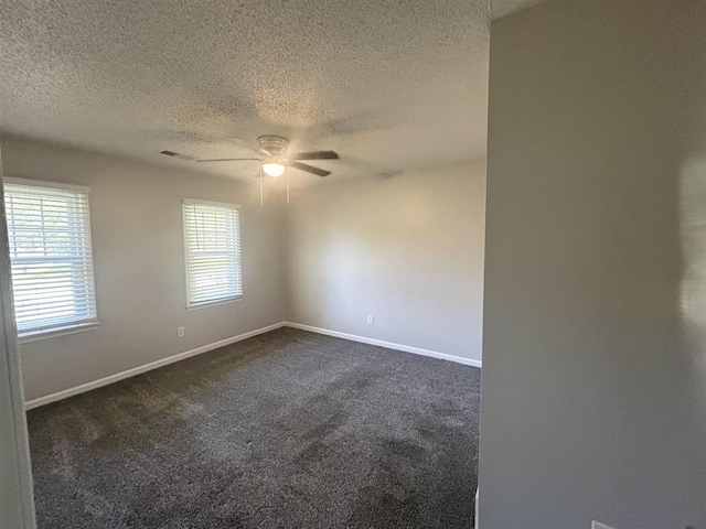 empty room with a ceiling fan, a textured ceiling, visible vents, baseboards, and dark colored carpet