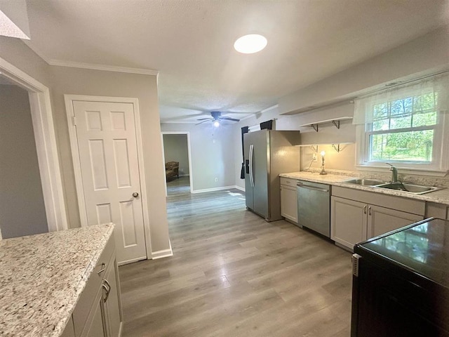 kitchen featuring open shelves, a sink, light wood-style flooring, stainless steel appliances, and a ceiling fan