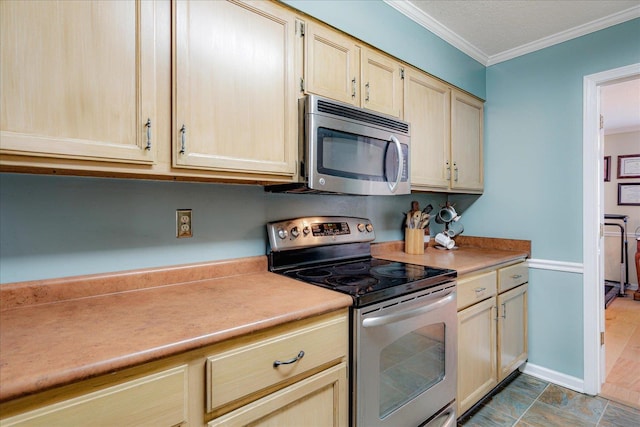 kitchen with baseboards, ornamental molding, appliances with stainless steel finishes, and light countertops