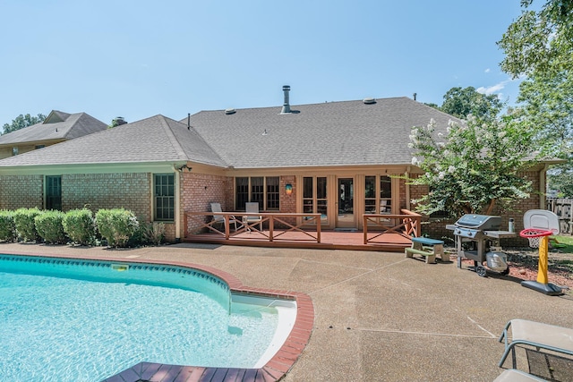 view of swimming pool with a fenced in pool, a grill, a wooden deck, and a patio