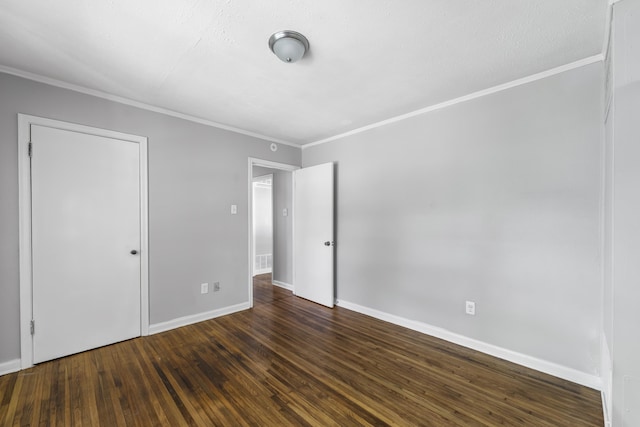 unfurnished bedroom with crown molding, baseboards, visible vents, and dark wood-type flooring