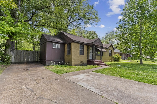 bungalow-style home with a front lawn, roof with shingles, brick siding, a gate, and crawl space