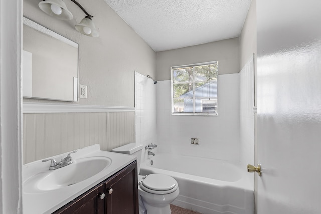 full bathroom with a textured ceiling, wainscoting, vanity, toilet, and tub / shower combination
