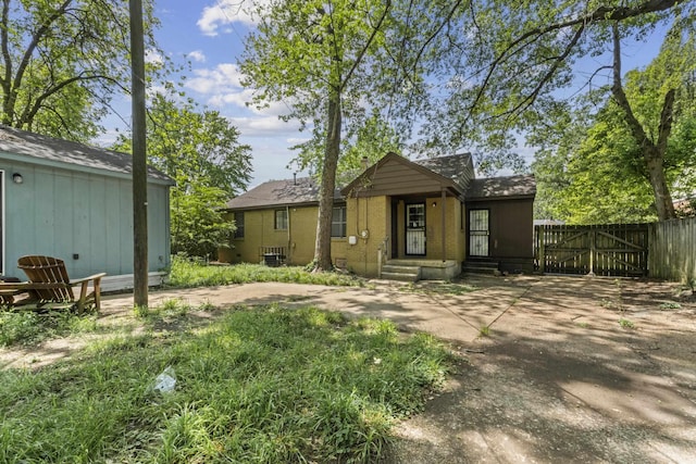back of property with fence and a gate