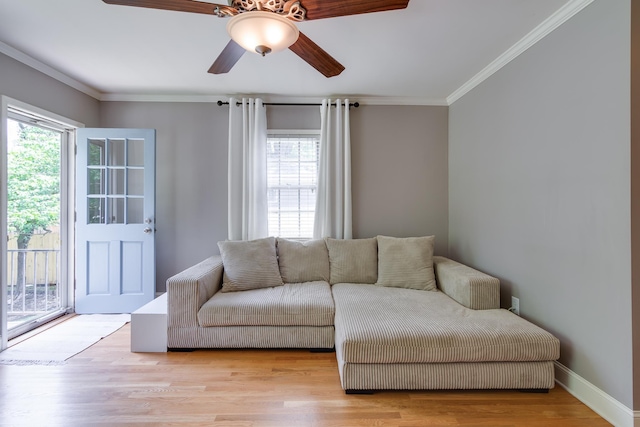 living room featuring a ceiling fan, baseboards, ornamental molding, and wood finished floors