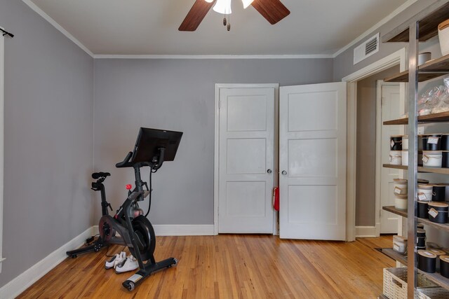 exercise room with crown molding, baseboards, light wood-style floors, and a ceiling fan