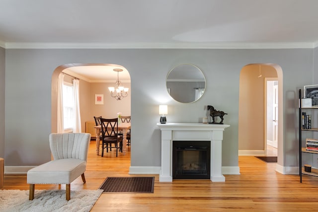 living room featuring visible vents, arched walkways, light wood-style floors, and crown molding