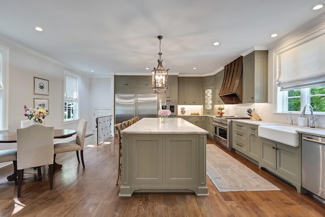 kitchen with a notable chandelier, a sink, premium appliances, gray cabinetry, and custom exhaust hood