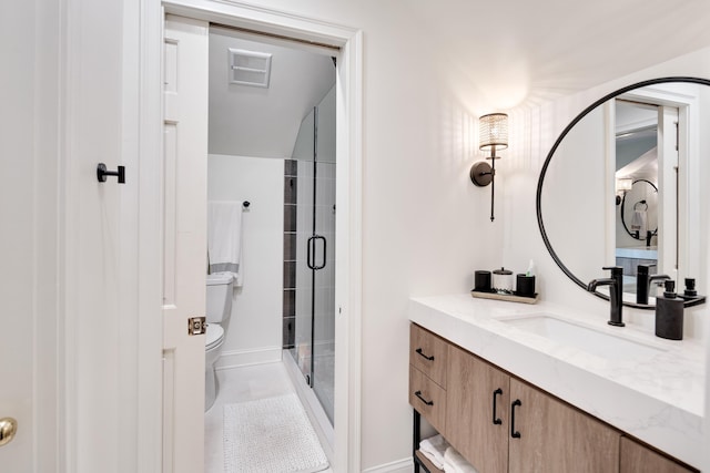 bathroom featuring vanity, baseboards, a stall shower, and toilet