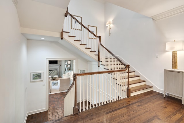 stairs featuring baseboards and a high ceiling
