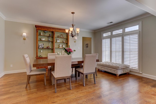 dining room with visible vents, ornamental molding, a chandelier, and light wood-type flooring