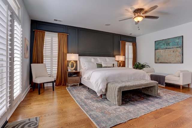 bedroom with light wood finished floors and multiple windows