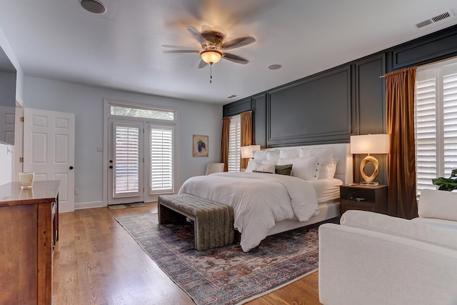 bedroom with ceiling fan, visible vents, access to exterior, and light wood finished floors