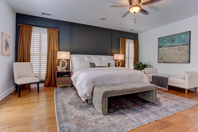 bedroom with a ceiling fan, light wood-style flooring, and visible vents