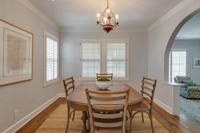 dining space featuring arched walkways, a notable chandelier, plenty of natural light, and wood finished floors