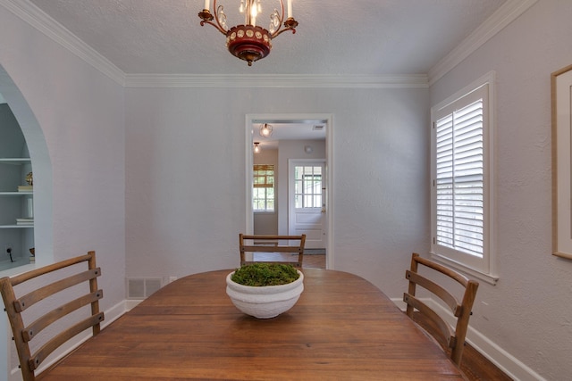 dining area with crown molding, arched walkways, visible vents, and a chandelier