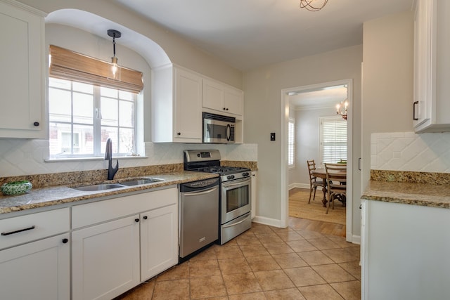 kitchen with white cabinets, appliances with stainless steel finishes, decorative backsplash, and a sink