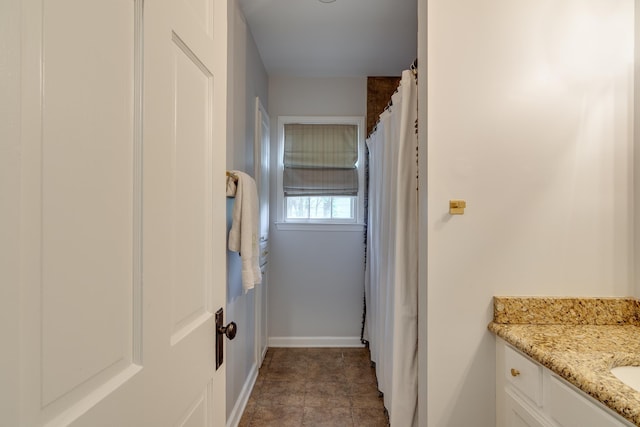 full bath with baseboards and vanity